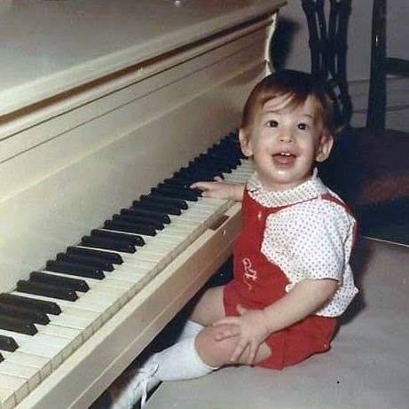 Jon Wolf as a toddler at a piano