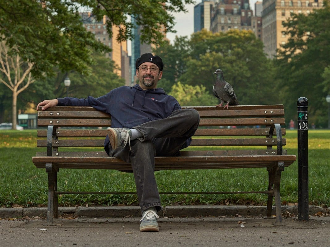 Jon Wolf on a park bench in the city